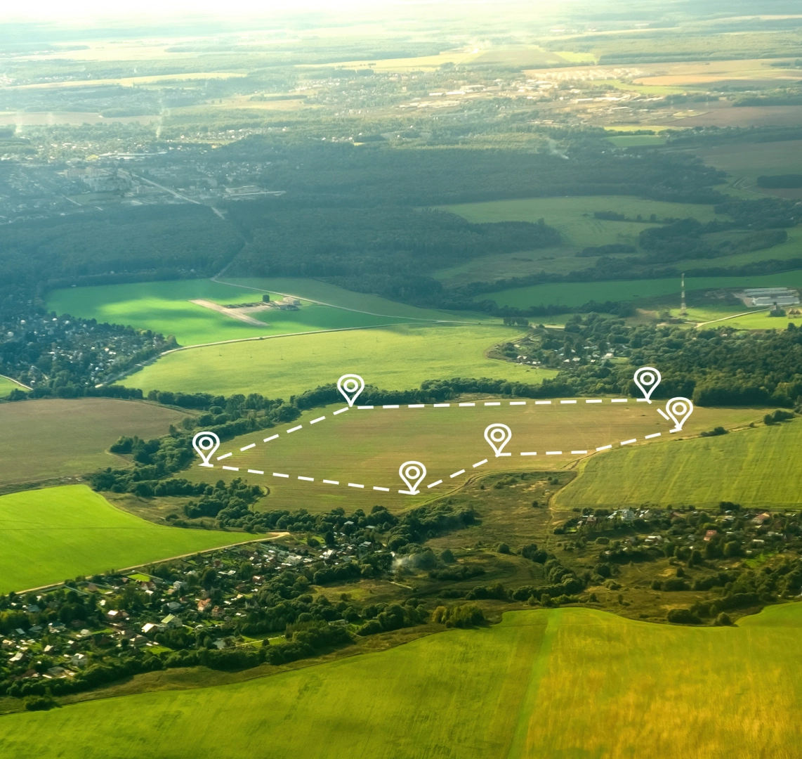 About h2 Aerial view of farmland with marked boundaries and location pins on a vast landscape of fields, trees, and distant communities.